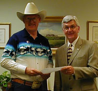 Cowboy Poet Lariat Ron Wilson presents an original cowboy poem to Chuck Shroeder for inclusion at the National Cowboy Hall of Fame.